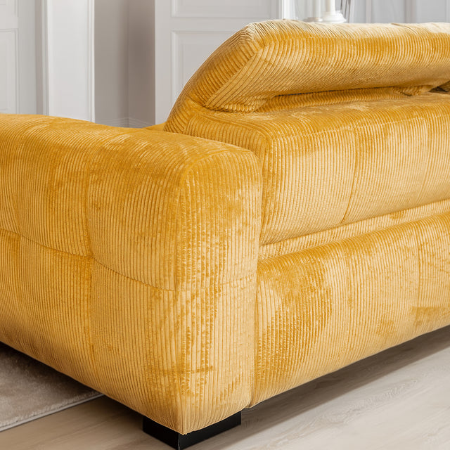 Detail du canape en velours cotele jaune moutarde avec accoudoir rembourre.