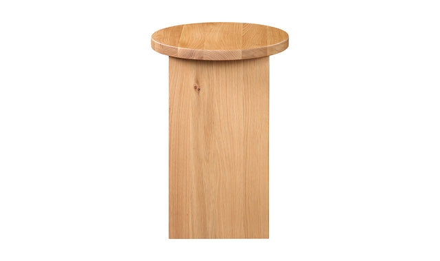 Table d'appoint en bois clair au design minimaliste pose sur tapis texture dans un interieur moderne.