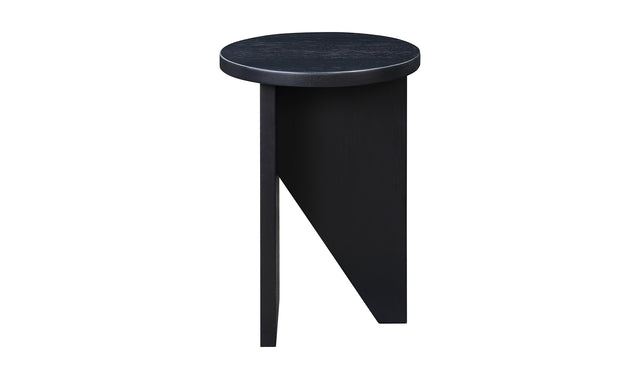 Table d'appoint en bois noir au design minimaliste pose sur tapis texture dans un interieur moderne.