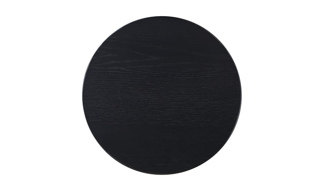Table d'appoint en bois noir au design minimaliste pose sur tapis texture dans un interieur moderne.
