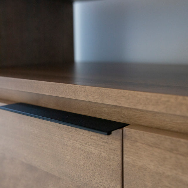 Détail du buffet Anabel en merisier, mettant en valeur la beauté naturelle du bois. Detail of the Anabel sideboard in cherry wood, highlighting the natural beauty of the wood.