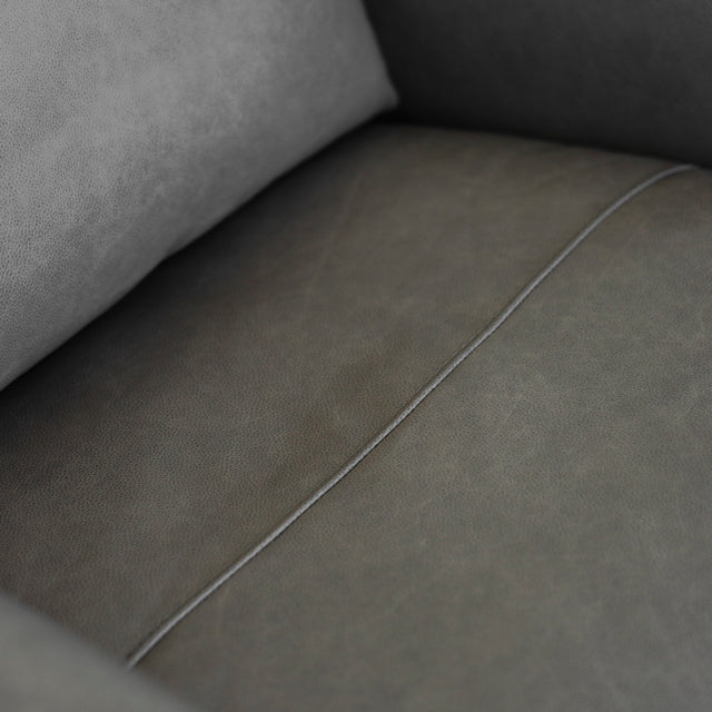 zoom sur l assise du fauteuil en cuir gris avec couture centrale elegante.