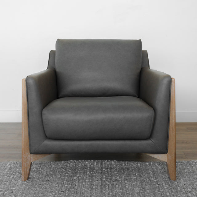 fauteuil contemporain en cuir gris avec accoudoirs et base en bois clair.