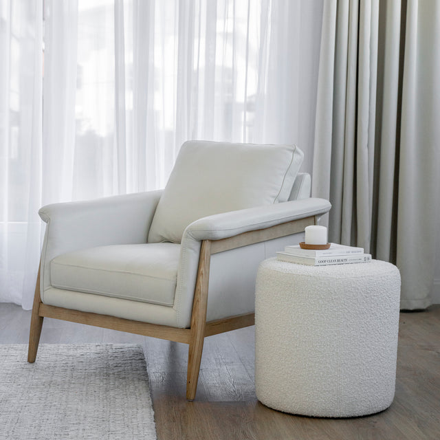 Fauteuil en cuir crème avec structure en bois clair dans un salon lumineux.