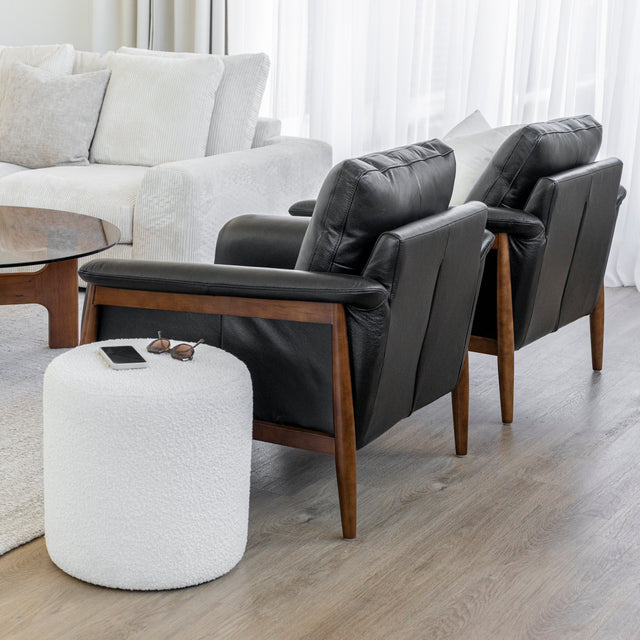 Fauteuil en cuir noir avec structure en bois dans un salon moderne.