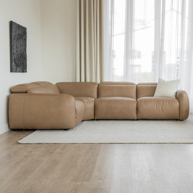 canape d angle en cuir beige clair avec coussin creme dans un salon lumineux et rideaux beiges.