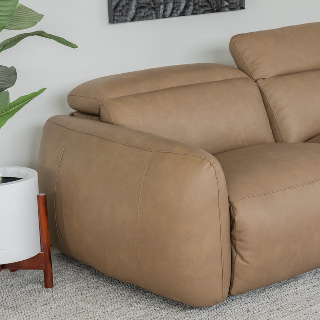 gros plan sur l accoudoir du canape en cuir beige clair mettant en valeur les coutures et la texture lisse.