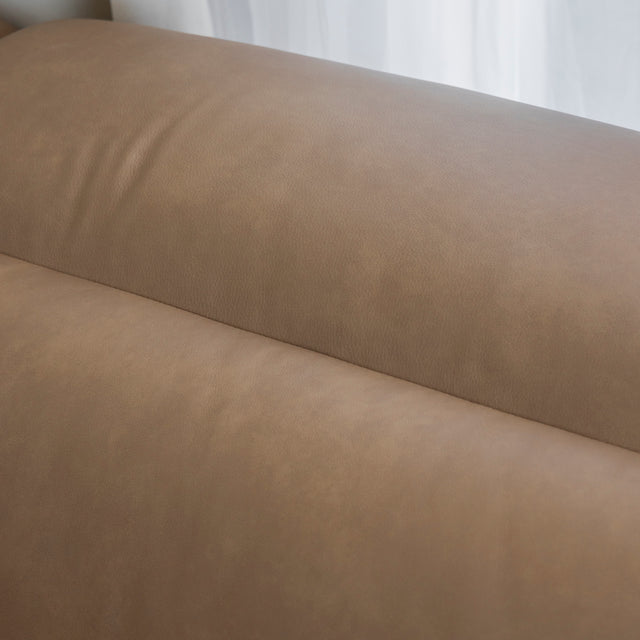 gros plan sur la couture et la texture lisse du cuir beige clair du canape.
