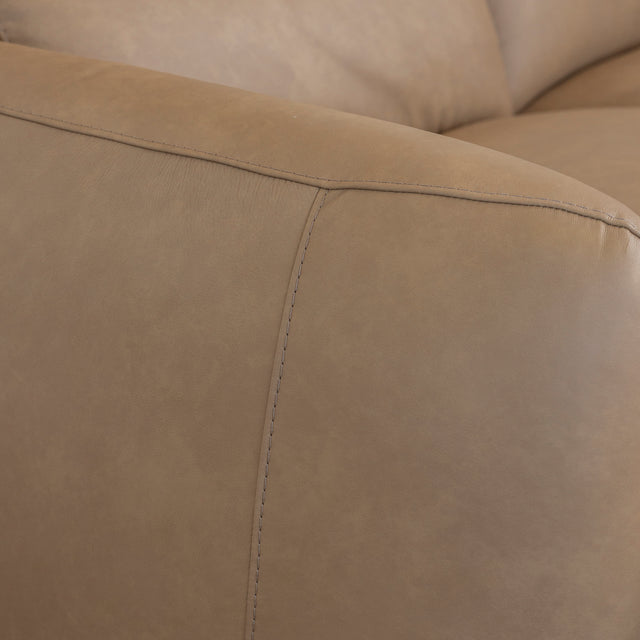 gros plan sur la couture et la texture lisse du cuir beige clair du canape.