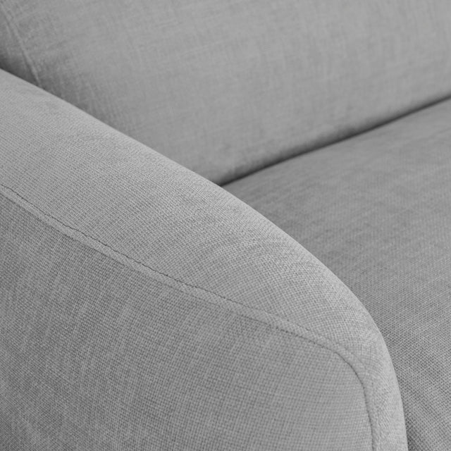 detail de l accoudoir du canape gris clair en tissu texture douce et elegante.