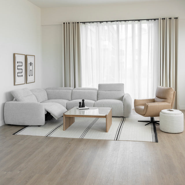 salon lumineux avec canape d angle gris clair table basse en bois et fauteuil beige.