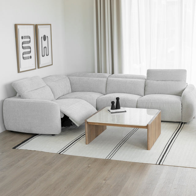 canape d angle inclinable en tissu gris clair avec repose pieds ouvert et table basse en bois clair.