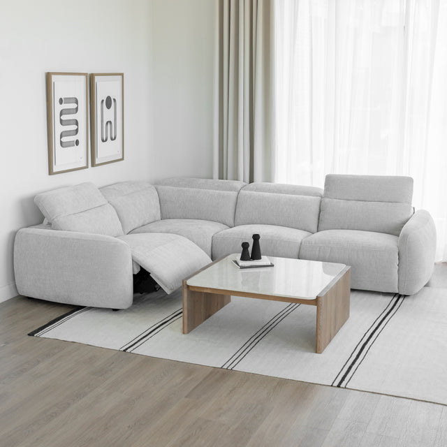 canape d angle inclinable en tissu gris clair avec repose pieds ouvert et table basse en bois clair.