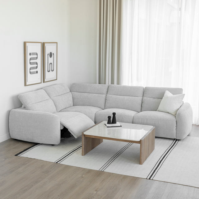 canape d angle gris clair avec dossier inclinable et repose pieds ouvert dans salon lumineux.