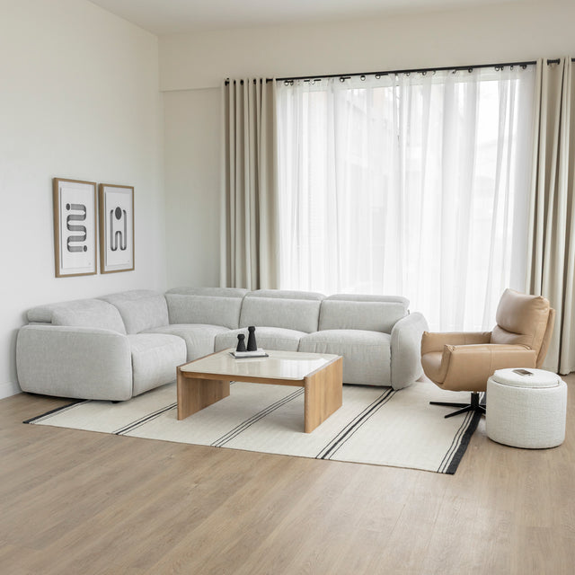 salon moderne avec canape d angle gris clair table basse en bois et fauteuil beige.