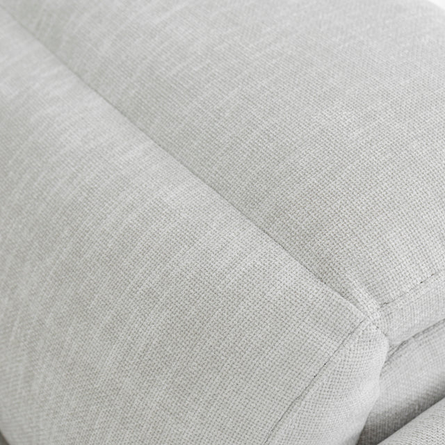 zoom sur le dossier rembourre du canape gris clair en tissu texture douce.
