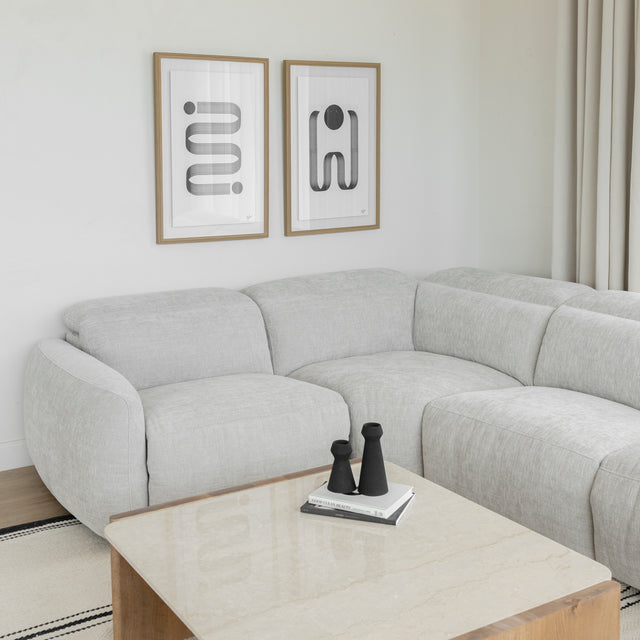 detail de l accoudoir du canape gris clair en tissu avec table basse en bois et tapis clair.