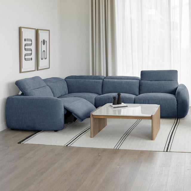 canape d angle bleu inclinable avec table basse en bois sur tapis clair a rayures.