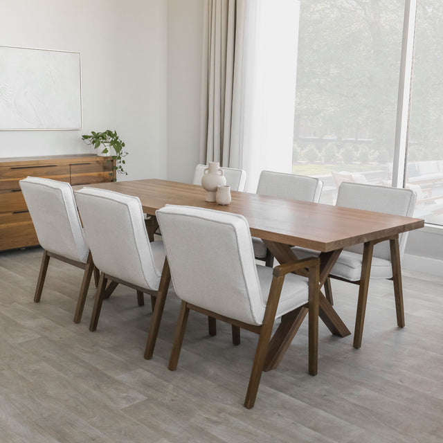 Salle a manger moderne avec grande table en bois, chaises grises et luminaire suspendu devant large fenetre.
