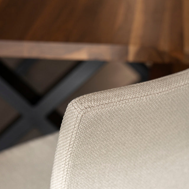 chaise moderne en tissu beige avec pattes noires.