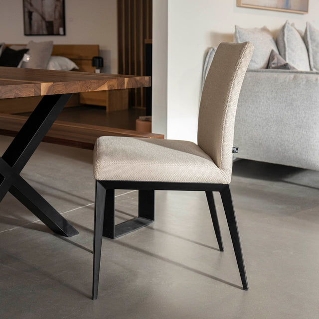 chaise moderne en tissu beige avec pattes noires.