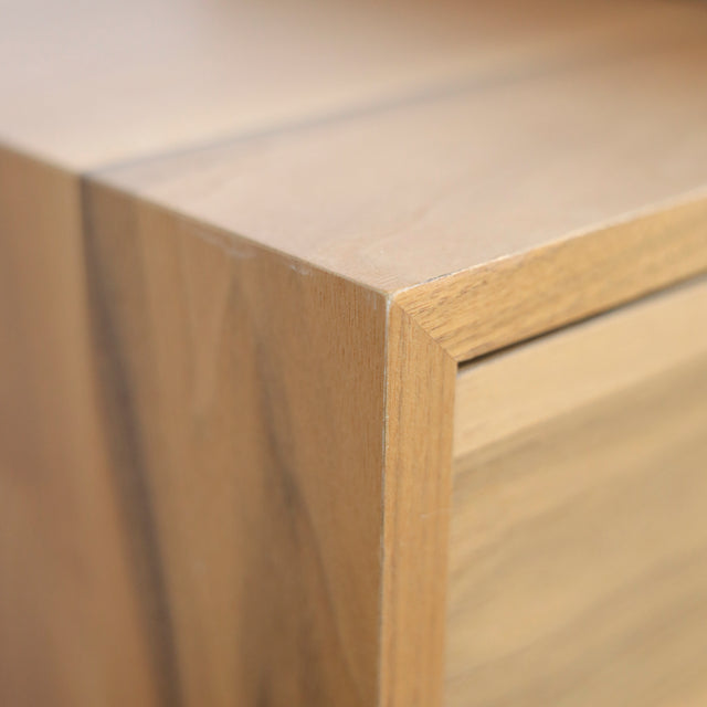 Image rapprochée d'un Meuble TV moderne en bois de noyer et beton gris avec tiroirs et etageres ouvertes.