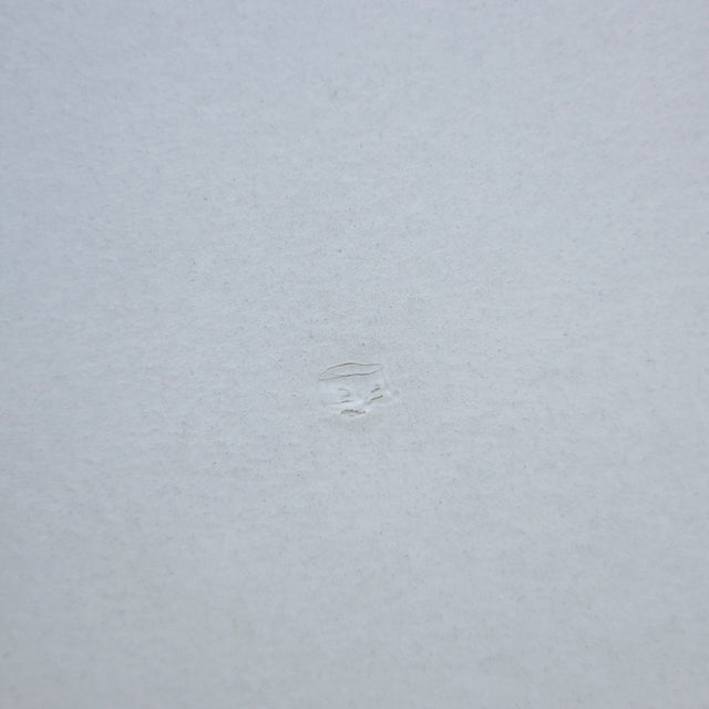 Image rapprochée comportant un défaut d'une Table rectangulaire moderne avec plateau en béton gris clair et pieds metalliques noirs.