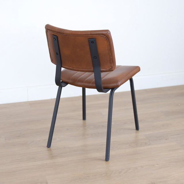 chaise vintage cognac avec assise matelassee et pieds en metal noir.