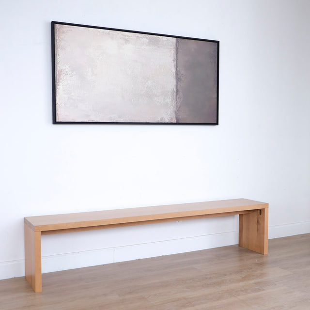 banc en bois clair au design minimaliste posé contre un mur blanc.