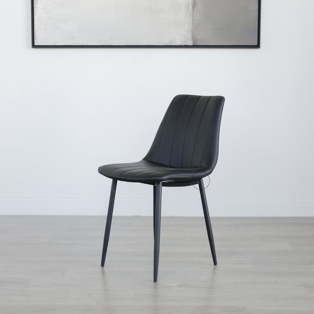 chaise moderne en simili cuir noir avec pieds en metal fins.
