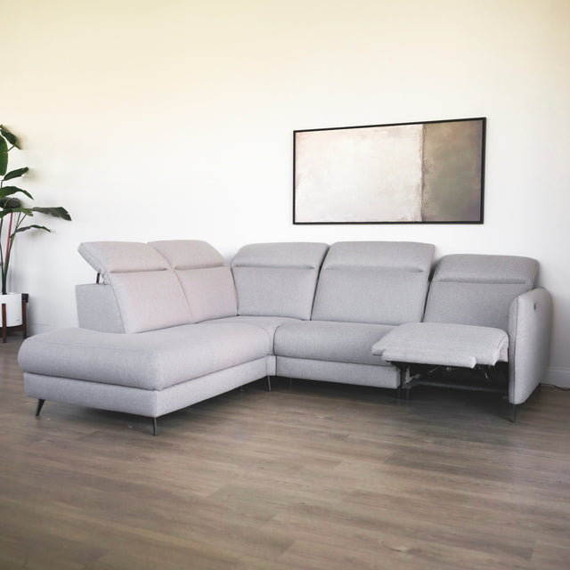 canape d angle gris clair moderne avec accoudoirs et pieds noirs dans salon minimaliste.