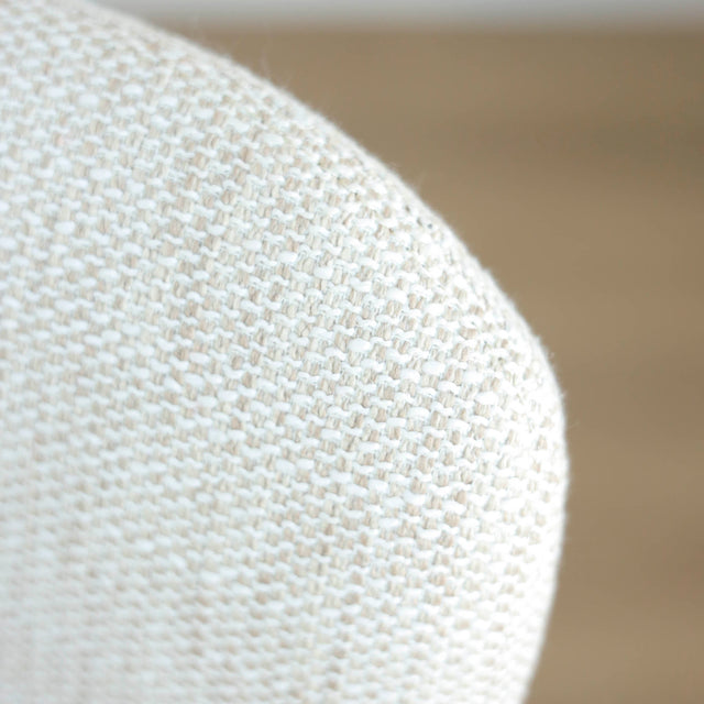 Image rapprochée du tissu d'un lot de trois chaises style scandinave avec structure en bois et assise beige rembourree.