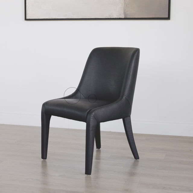 chaise contemporaine en cuir végane noir avec design incurve et pieds assortis avec cercles indiquant les défauts.