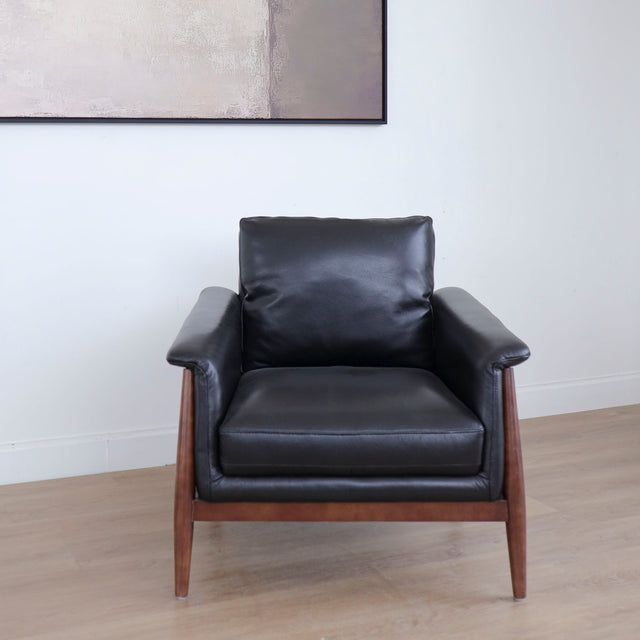 Fauteuil en cuir noir avec structure en bois style moderne.
