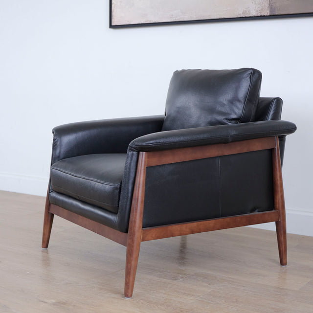 Fauteuil en cuir noir avec structure en bois style moderne.