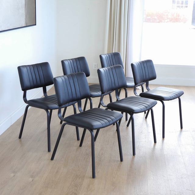 ensemble de chaises noires style vintage avec assise et dossier matelassé.