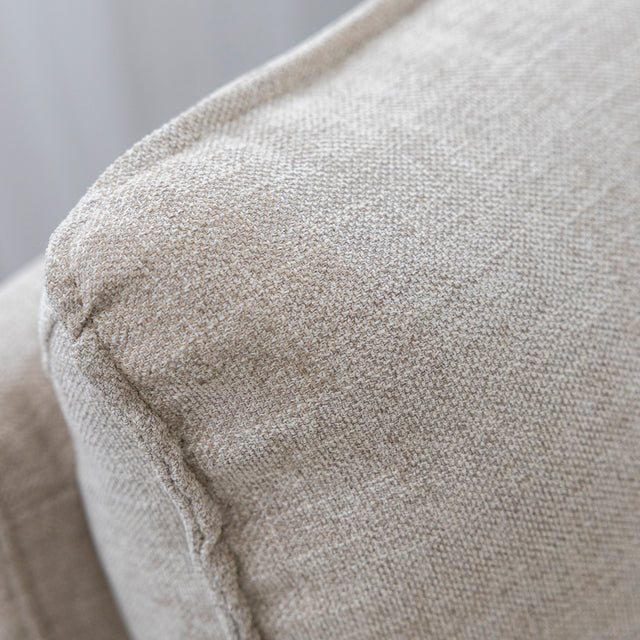 Gros plan sur la texture du tissu beige du canape sectionnel moderne.