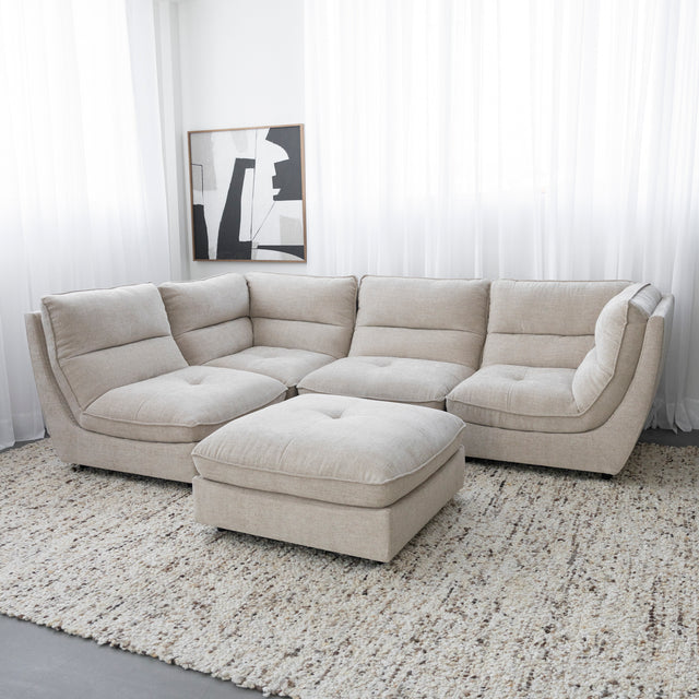 Canape sectionnel beige moderne avec pouf assorti sur grand tapis texture clair.