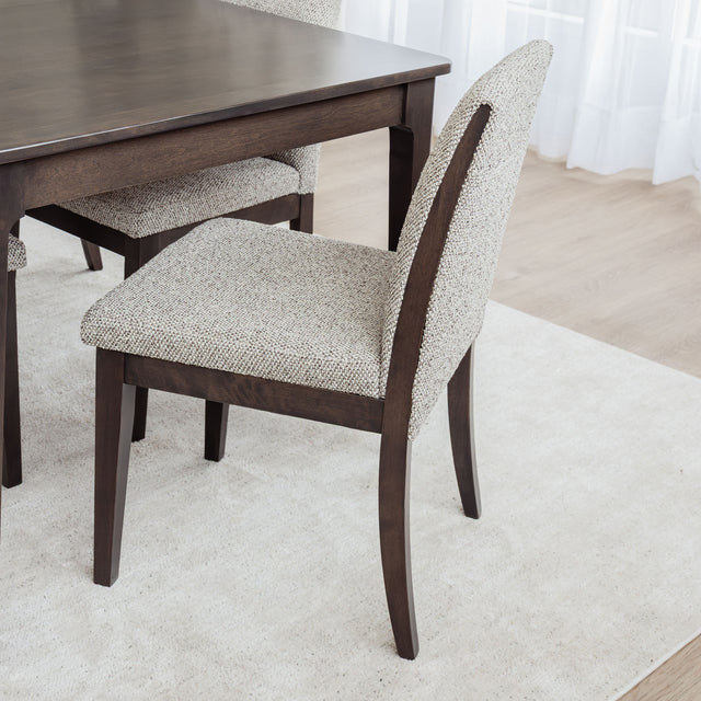 Table de salle à manger en bois foncé avec chaises rembourrées en tissu beige, style contemporain.