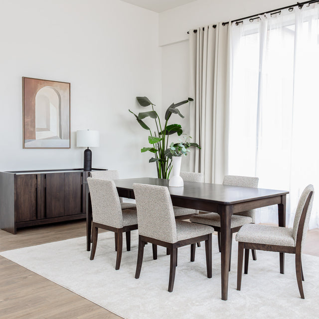 Table de salle à manger en bois foncé avec chaises rembourrées en tissu beige, style contemporain.
