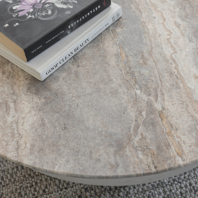 Gros plan sur plateau de table ronde en pierre naturelle avec livres poses dessus.