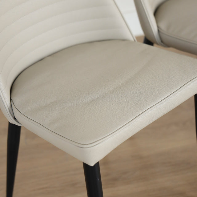 Deux chaises modernes taupe avec pieds noirs coniques, design elegant pour salle a manger.