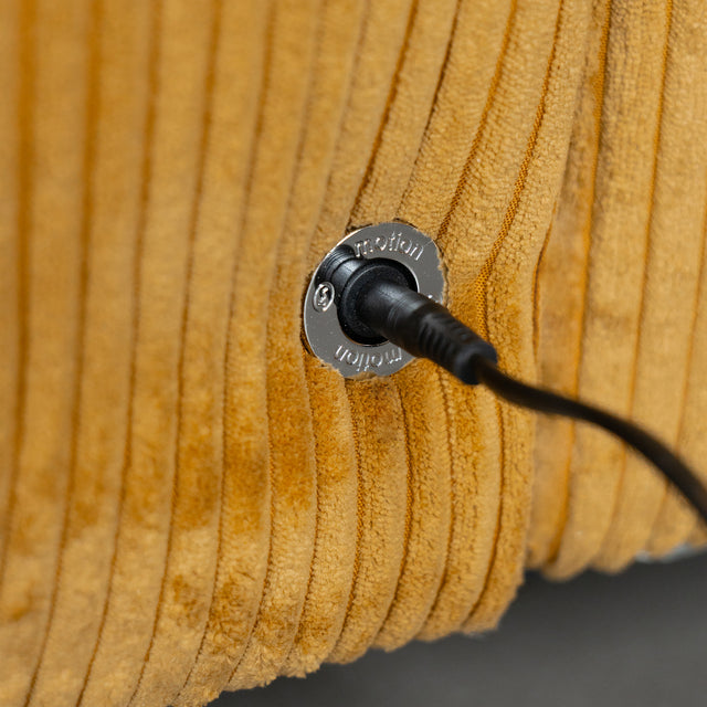 Prise de recharge integree sur canape en velours cotele jaune moutarde.