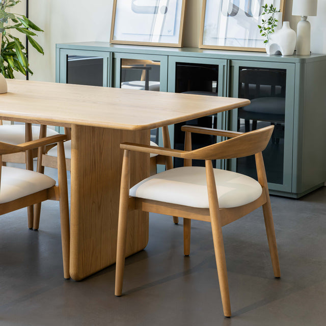 Table de salle à manger en chêne clair avec chaises assorties et buffet moderne dans un intérieur scandinave lumineux.
