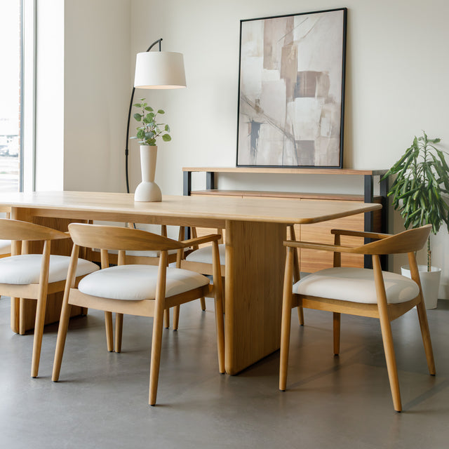 Salle à manger avec table en chêne massif et chaises design scandinaves.