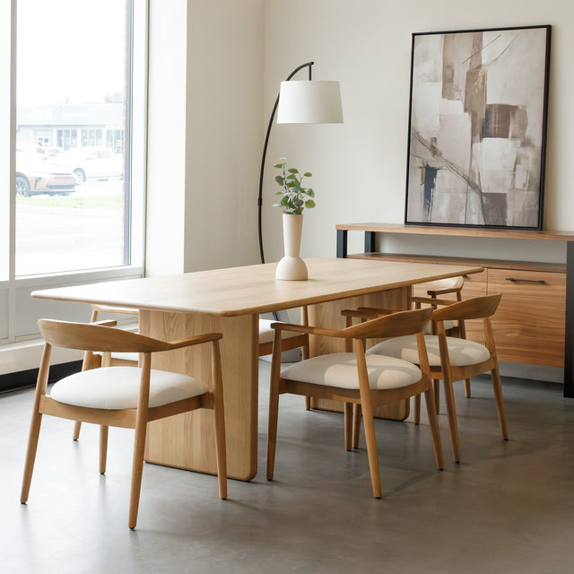 Salle à manger avec table en chêne massif et chaises design scandinaves.