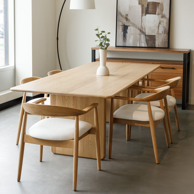 Salle à manger avec table en chêne massif et chaises design scandinaves.