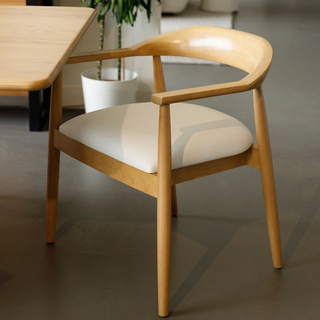 Chaise de cuisine en bois merisier avec assise rembourrée cuir végane beige style scandinave.