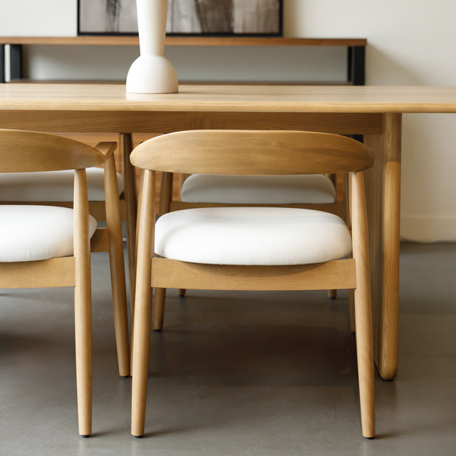 Chaise de cuisine en bois merisier avec assise rembourrée cuir végane beige style scandinave.