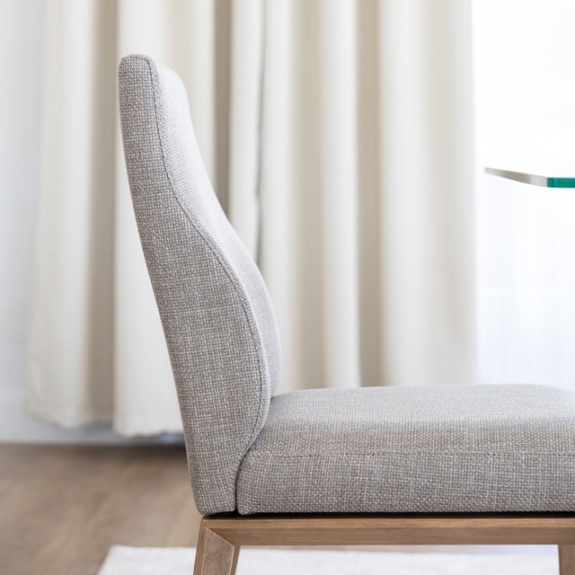 Chaise de cuisine en tissu beige avec pieds en bois naturel dans un intérieur moderne.